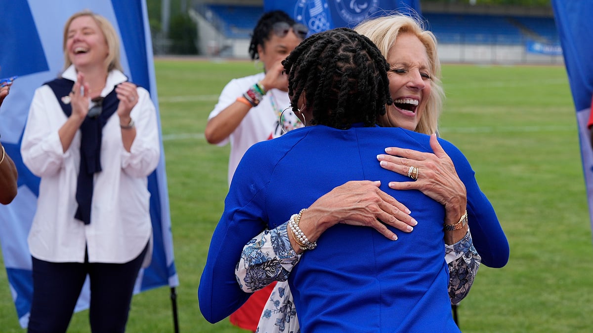 (AP Photo/George Walker IV) : First lady Jill Biden, right, hugs U.S. track and field athlete Melissa Jefferson at the team's training facility during the 2024 Summer Olympics, Thursday, July 25, 2024, in Eaubonne, France. 
